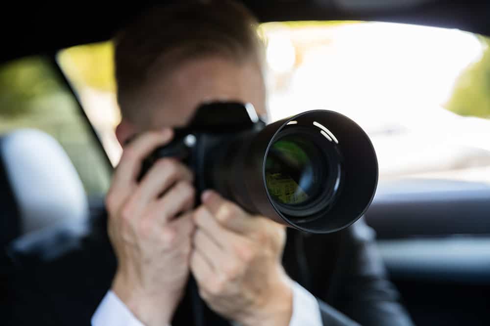 Private investigator conducting surveillance with camera