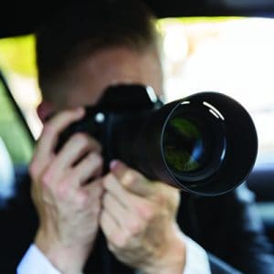 Private Detective Sitting Inside Car Doing Surveillance Work Photographing With Camera