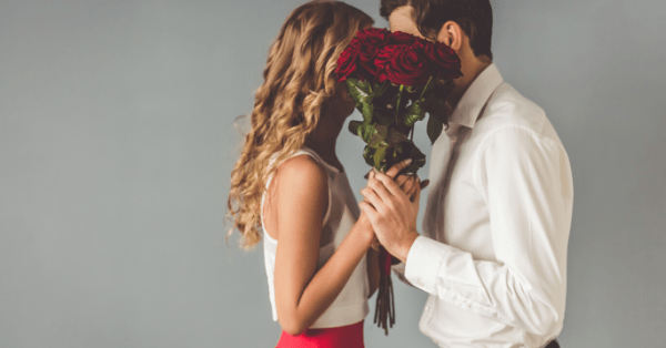 couple-hiding-behind-a-bunch-of-roses