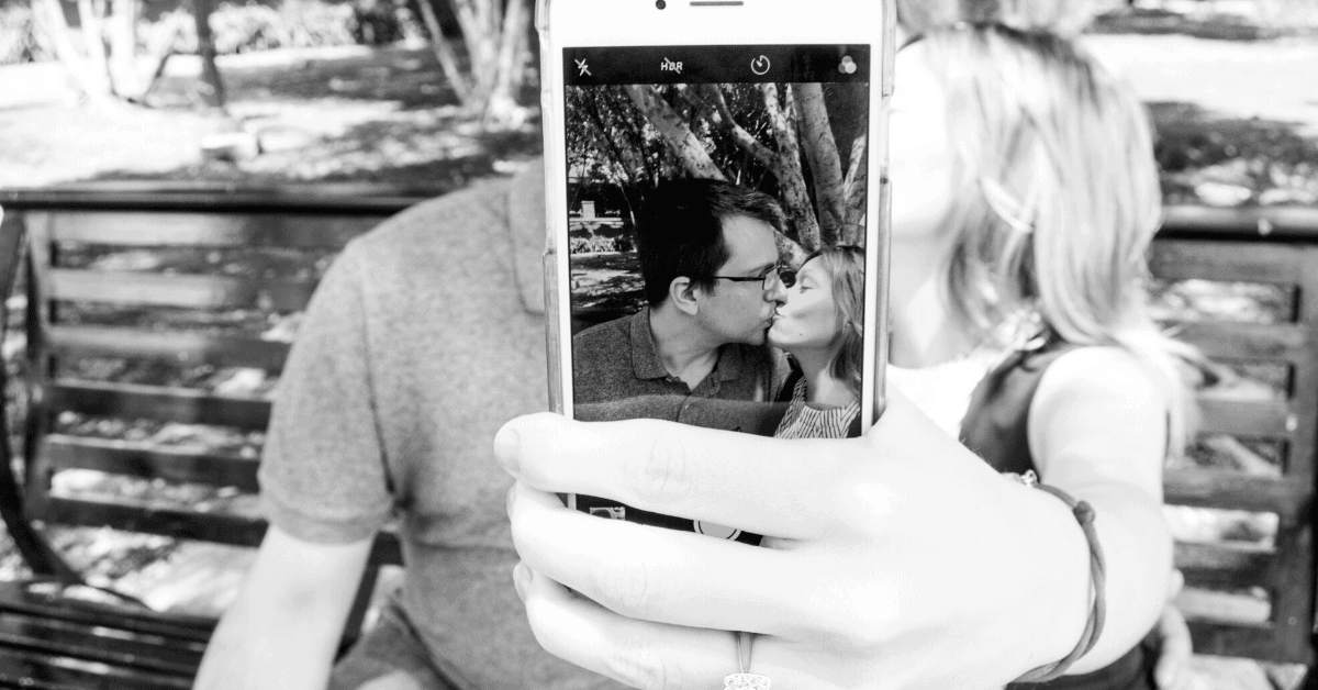 couple kissing on iphone